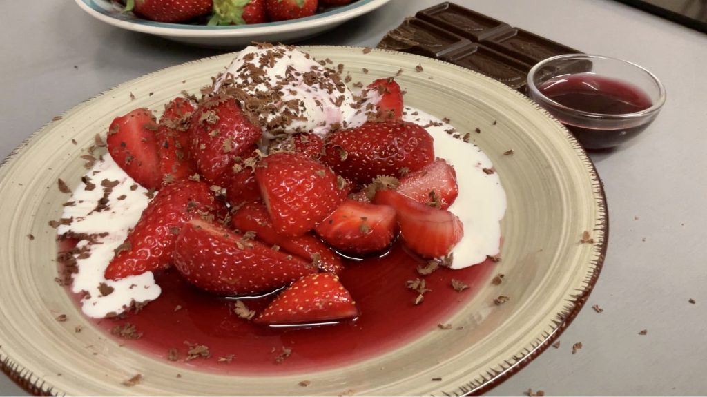 Destacar la ligereza y buen aspecto de este sencillo postre de fresones al vino tinto con nata y chocolate negro en virutas. ¡Todo un espectáculo!