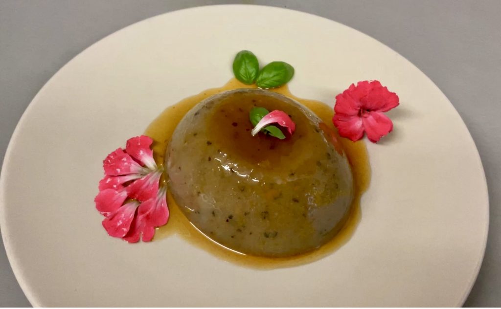 Sencillamente precioso este flan de olivada y naranja, solo decorado con unos pétalos de clavel mini y unas hojitas de albahaca.